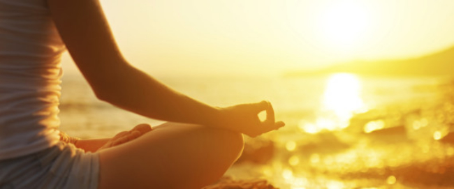 hand of woman meditating in a yoga pose on beach